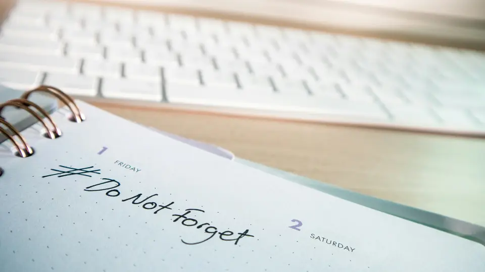 Spiral desk diary open at Friday 1 and Saturday 2 with '#Do Not Forget' handwritten, in front of a white keyboard