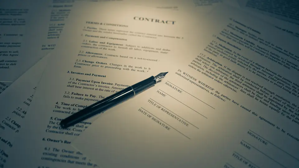 A black fountain pen resting on a printed contract headed Contract, with numbered terms and conditions and blank signature, name and date lines, surrounded by other contract pages
